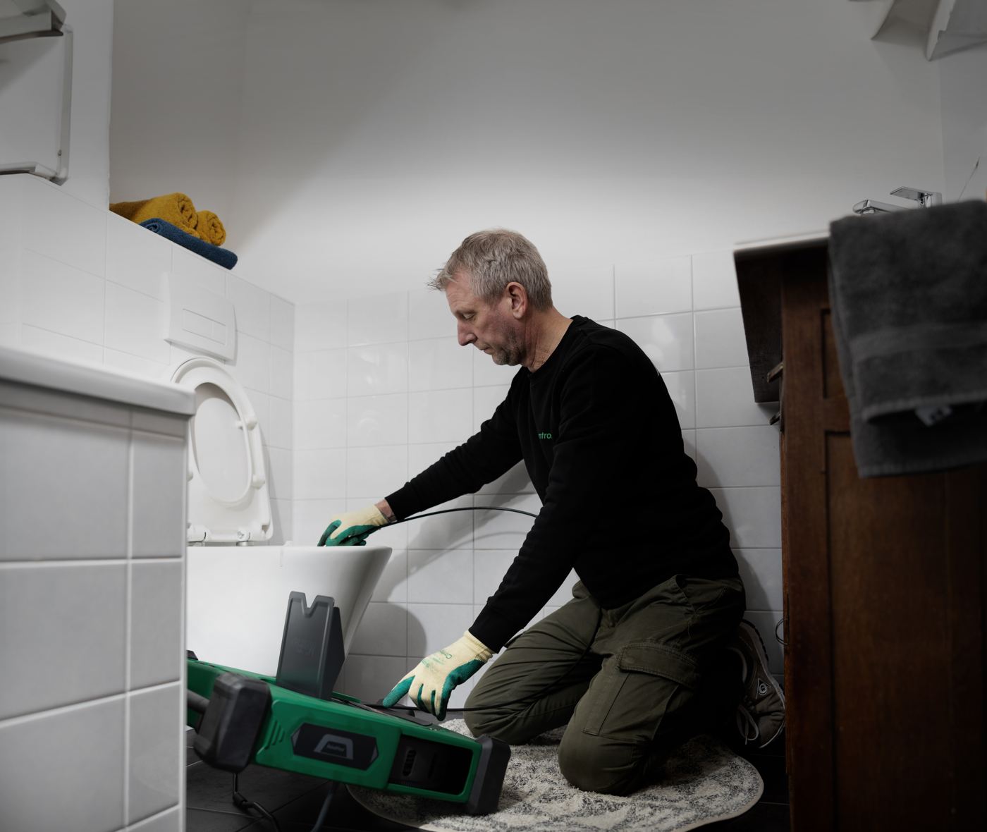 Plumber running the MiniFlex into a toilet line